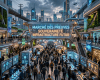 Crowded futuristic marketplace with digital displays and neon signs highlighting sovereignty and future infrastructure